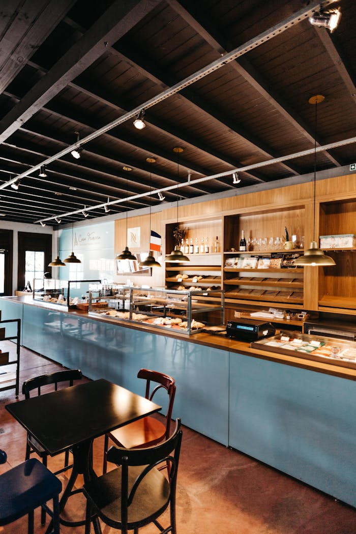 Spacious rustic cafe interior with wooden furniture and a bar area, ideal for a cozy dining experience.