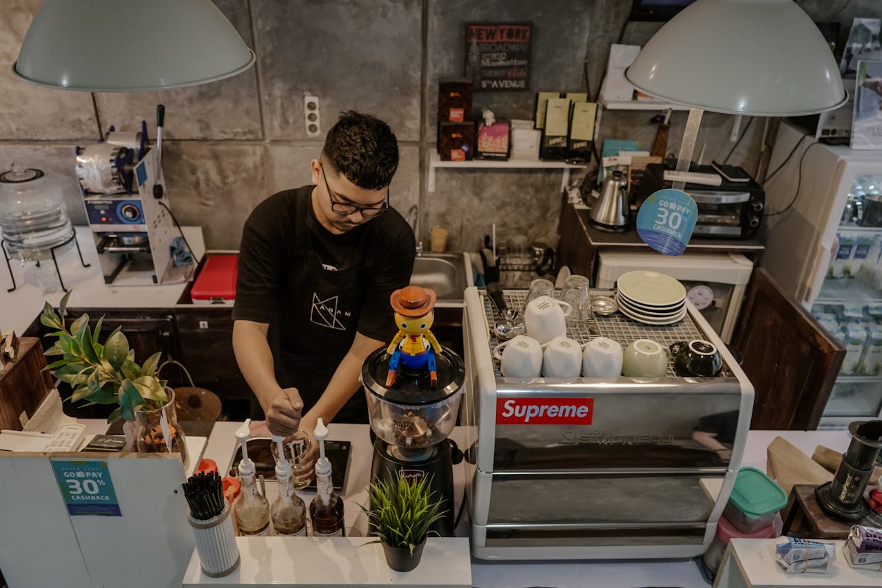 A barista attentively prepares coffee in a trendy indoor café setting.